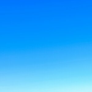 A serene view of a vibrant clear blue sky with a subtle gradient, perfect for backgrounds.